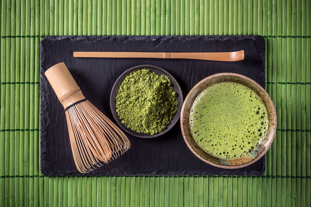 Matcha Tee in Schale drapiert mit Bambus Besen, Bambuslöffel und Match Schale